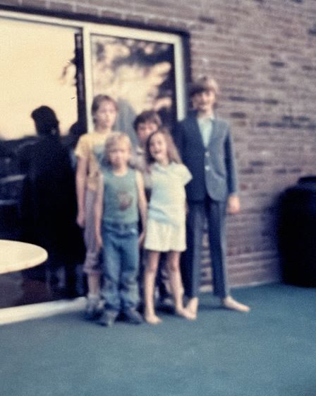 A young Chris Meece in a suit, barefoot, before his first magic show on his parents’ back porch